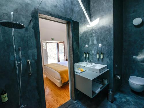 a bathroom with a bed and a sink and a shower at Morgadio da Calcada Douro Wine&Tourism in Provesende