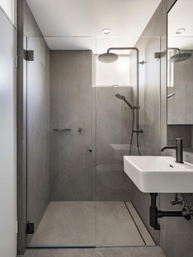 a bathroom with a glass shower and a sink at Panoramic Sydney Harbour Views from Luxury 1-Bedroom Apartment in McMahons Point in Sydney