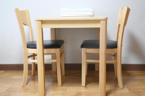 a wooden table with two chairs and a table with papers on it at Sorak Hostel in Sokcho