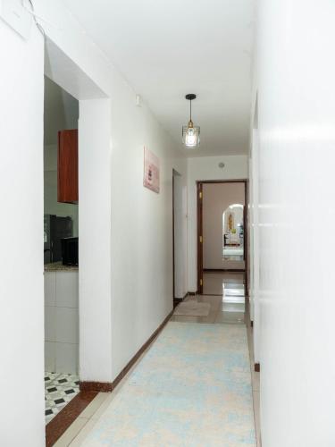 a hallway with white walls and a blue rug at Perfect Palm Condos-N12 in Nakuru