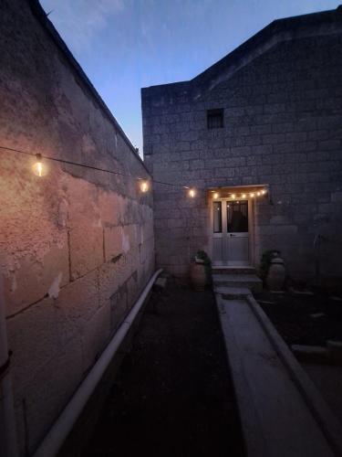 a brick building with a door with lights on it at La Fuitina - Dimora Storica in Cursi