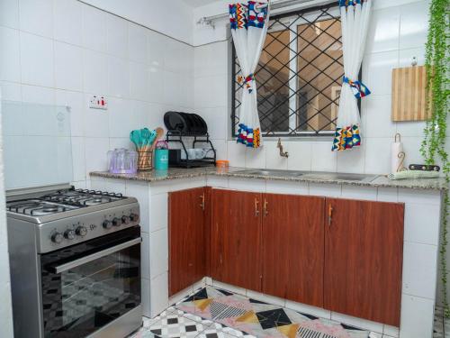 a kitchen with a stove and a window at Perfect Palm Condos-N12 in Nakuru