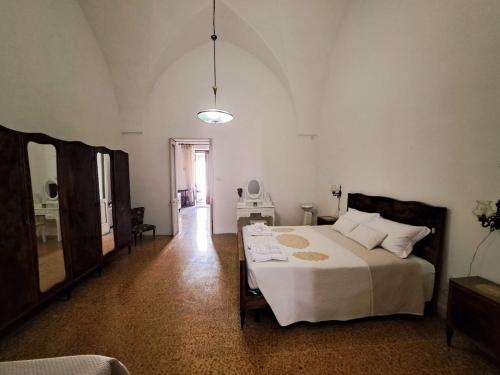a bedroom with a large bed and a mirror at La Fuitina - Dimora Storica in Cursi