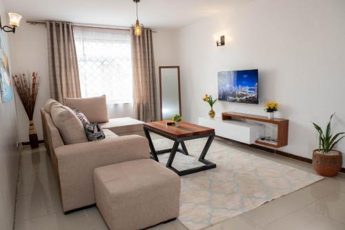 a living room with a chair and a table at Perfect Palm Condos-N12 in Nakuru
