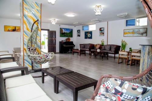 a living room with couches and chairs and a piano at Golden Hotel in Nungwi