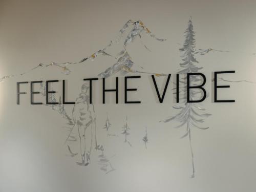 a sign that reads feel the vibe with trees at ViBES Sölden - your alpine homebase in Sölden