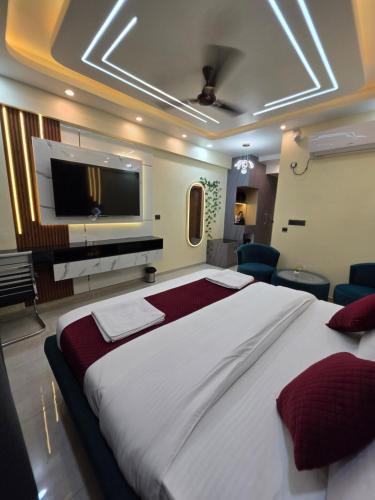 a bedroom with a large bed with a flat screen tv at The Elite Ohana in Lucknow