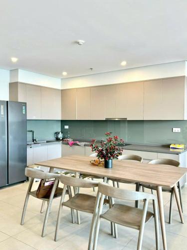 a large kitchen with a wooden table and chairs at The Song Luxury Vung Tau Apartment - QUỲNH's Homestay in Vung Tau