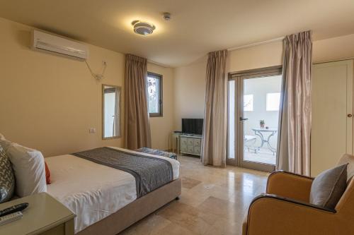a bedroom with a bed and a sliding glass door at Yehelim Boutique Hotel in Arad