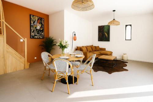 a living room with a table and chairs and a couch at Rêves de Canopée in Le Loroux-Bottereau