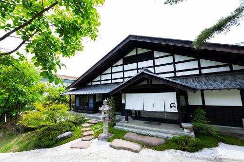 a japanese house with a black and white building at 旅庵 川喜 in Omachi