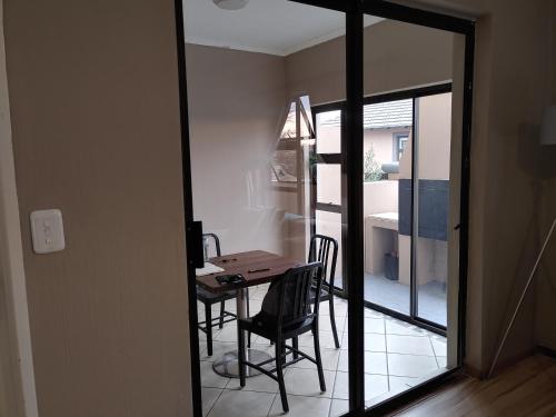 a dining room with a table and chairs and a mirror at Sunrise Mountains View in Krugersdorp