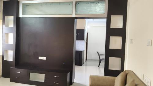a living room with a large tv and a couch at Hitech Shilparamam Guest House in Hyderabad