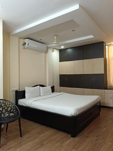 a bedroom with a large bed and a chair at Hitech Shilparamam Guest House in Hyderabad