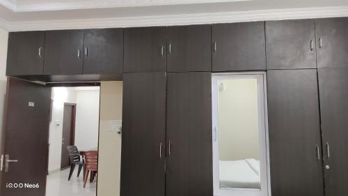 a room with brown cabinets and a dining room at Hitech Shilparamam Guest House in Hyderabad