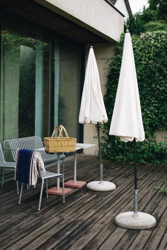 two umbrellas and a table and a bench on a deck at MÜHLENHOF ROOMS boutique bed & breakfast in Langenlois