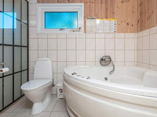 a bathroom with a tub and a toilet and a sink at 8 person holiday home in Glesborg-By Traum in Glesborg