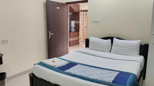 a bedroom with a large bed with white sheets and pillows at Hitech Shilparamam Guest House in Hyderabad