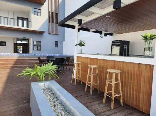 a patio with a bar and stools at Palm Rose Beach Resort in Nasugbu