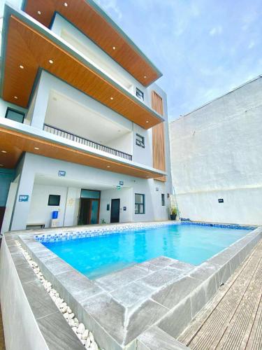 a swimming pool in front of a building at Palm Rose Beach Resort in Nasugbu