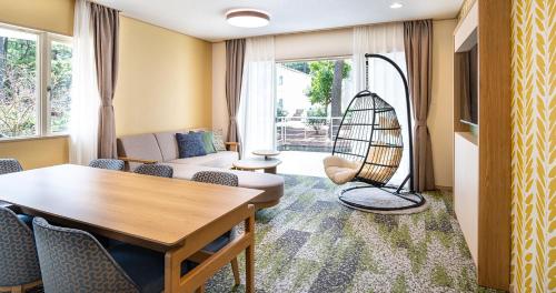 a living room with a table and chairs at Seagaia Forest Cottages in Miyazaki