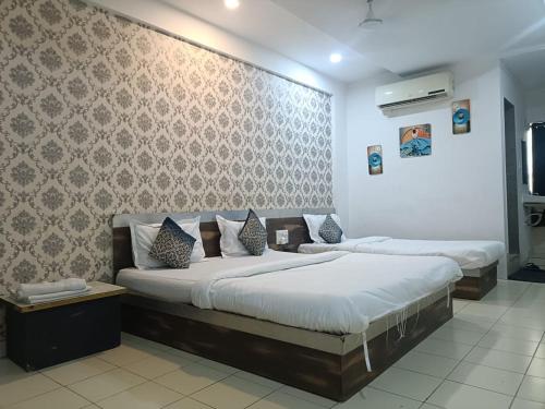 a bedroom with two beds and a wall at hotel philips in Ahmedabad