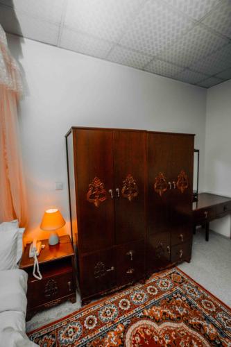 a large wooden cabinet in a room with a bed at Mbeya Forest Hill Motel in Mbeya