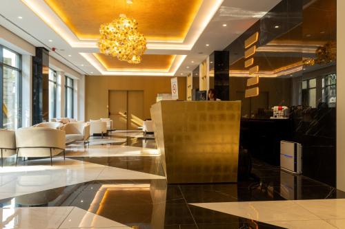 a lobby with white chairs and a chandelier at Zepterme Spa&Wellness Luxury Apartments member of Zepter hotels in Vrnjačka Banja