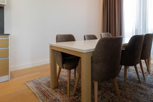 a dining room table with four chairs around it at Zepterme Spa&Wellness Luxury Apartments member of Zepter hotels in Vrnjačka Banja