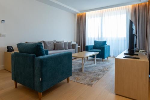 a living room with a couch and two chairs and a television at Zepterme Spa&Wellness Luxury Apartments member of Zepter hotels in Vrnjačka Banja