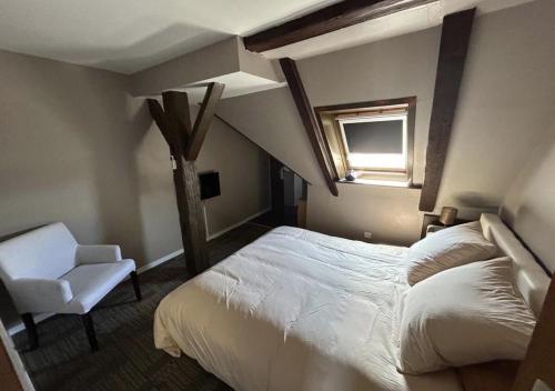 a bedroom with a large bed and a chair at Kalon - La Bonne Étoile in Kogenheim