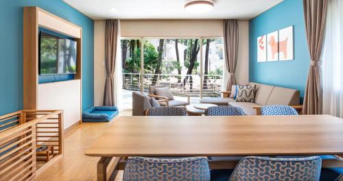 ein Wohnzimmer mit einem Holztisch und Stühlen in der Unterkunft Seagaia Forest Cottages in Miyazaki