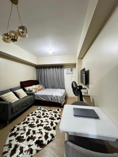 a living room with a bed and a couch at City Proper Avida Towers in Cagayan de Oro