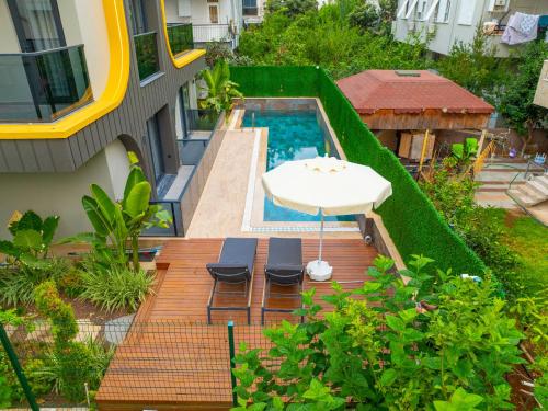 アンタルヤにあるZeluxe Suite Hotelの屋外デッキ(プール、テーブル、椅子付)