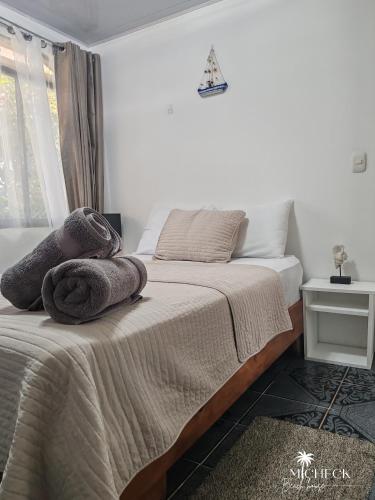 a bedroom with a bed with towels on it at Micheck beach house in Tortuguero