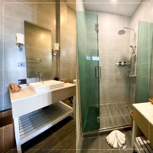 a bathroom with a sink and a glass shower at De Chaochom Hua Hin in Hua Hin