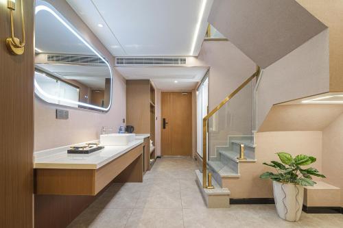 a bathroom with a sink and a shower and a staircase at Ouchen International Sky River Hotel (Monument to the people's Liberation Pedestrian Street Store, Chongqing) in Chongqing