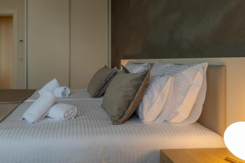 a bed with a bunch of pillows on it at Zepterme Spa&Wellness Luxury Apartments member of Zepter hotels in Vrnjačka Banja