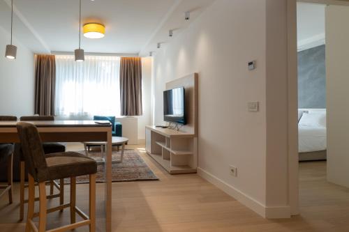 a hotel room with a dining table and a bed at Zepterme Spa&Wellness Luxury Apartments member of Zepter hotels in Vrnjačka Banja