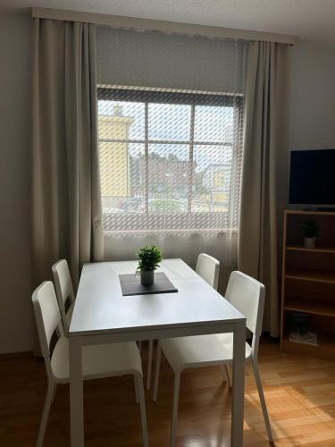 a dining room table with white chairs and a window at Gästehaus Barbara in Gablitz