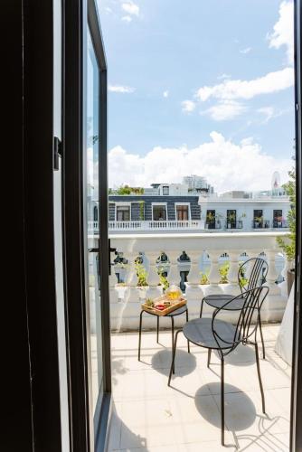 a balcony with a table and chairs and a view at Deja Vu House Ha Long in Ha Long