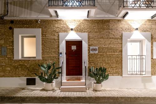 a brick wall with two potted plants in front of a door at Dimora 59 in Santa Maria Imbaro