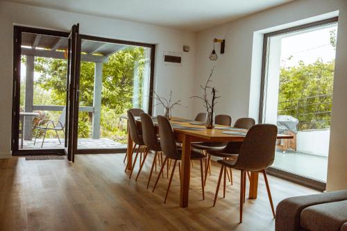a dining room with a wooden table and chairs at Sunset Hills Chalet in Slănic