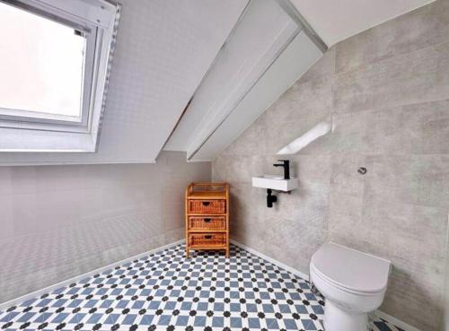 a bathroom with a toilet and a sink and a window at Central Charming Sea View Loft Flat in Troon