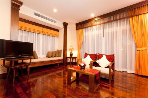 a living room with a couch and a tv at Sibsan Resort & Spa Maetaeng Chiang Mai in Mae Taeng