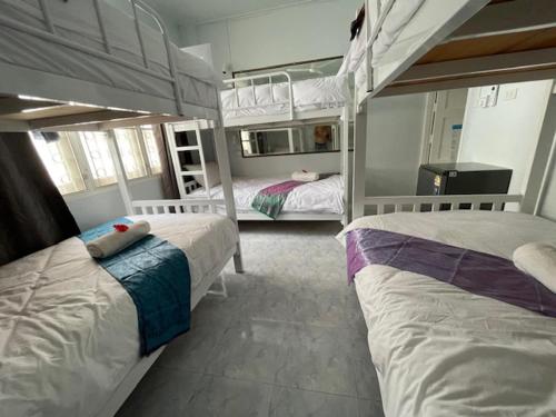 two beds in a room with two bunk beds at Mays Hostel in Hua Hin