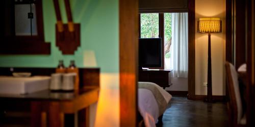 a bedroom with a bed and a television and a window at Sibsan Resort & Spa Maetaeng Chiang Mai in Mae Taeng