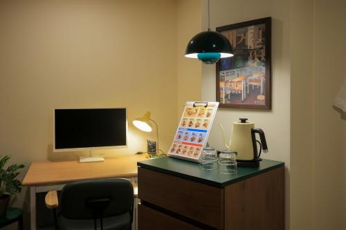 a room with a desk with a computer and a monitor at Aank Hotel Jeonju in Jeonju