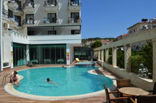 two people in a swimming pool in a building at Kalif Hotel in Ayvalık