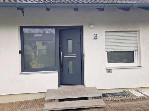 a blue door on a white house with a window at FeWo Royal & Goodness Home in Mühlhausen